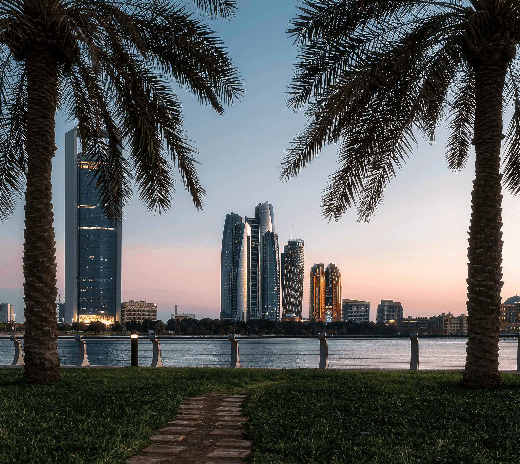a view of some very tall buildings by the water