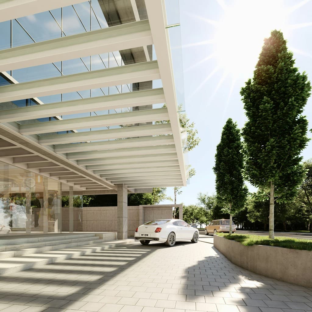 Modern building entrance with a white car arriving.